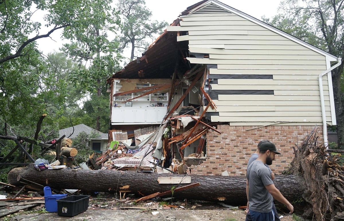 AP : People gather outside a home where Maria Loredo was killed when a tree crashed through her roof. 